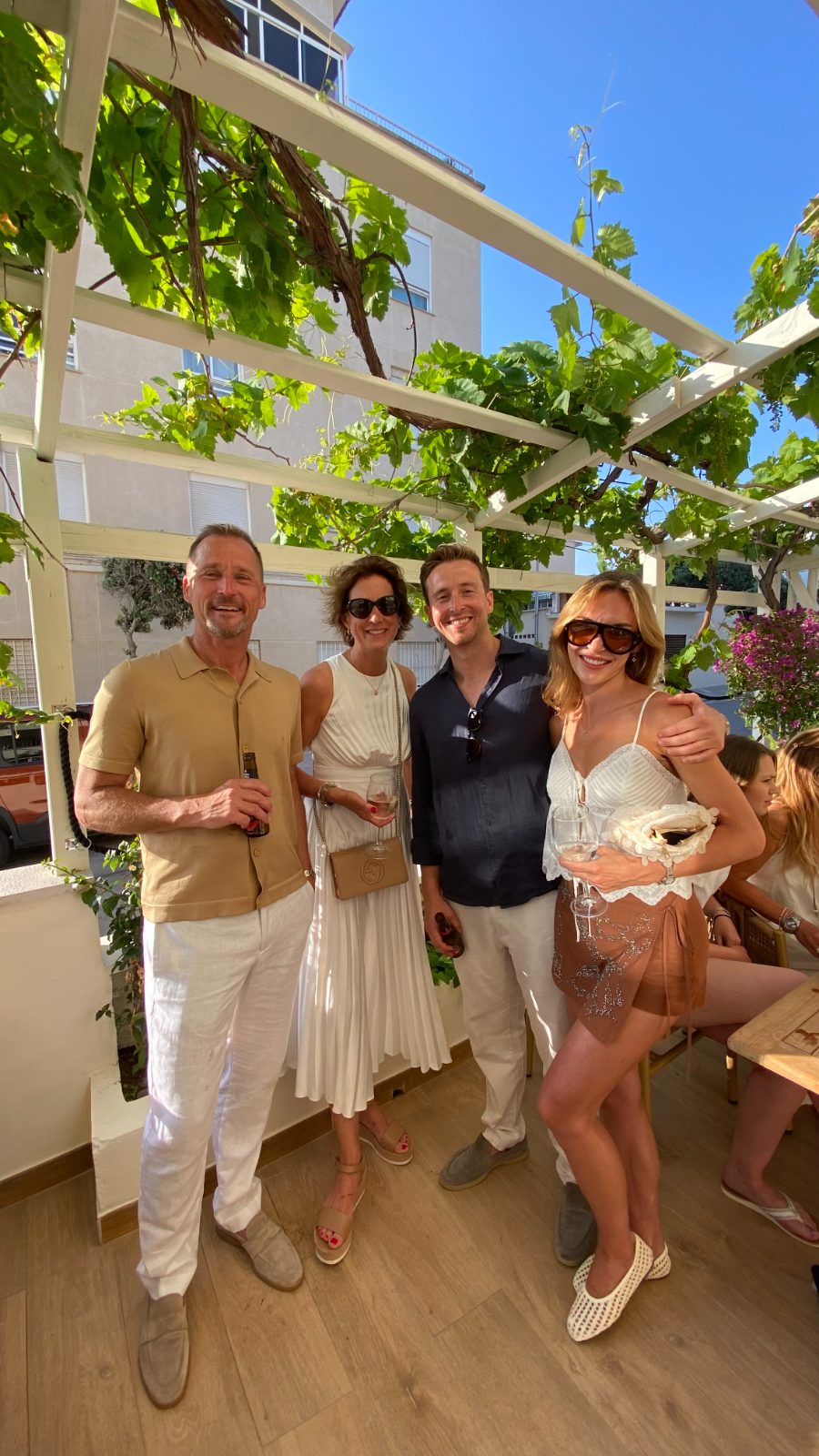 Invitados brindando bajo la parra en una celebración